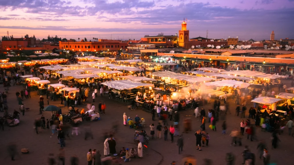 Bustling street scene in Marrakech, Morocco, with traditional architecture, local vendors, and vibrant colors reflecting the city's rich culture.