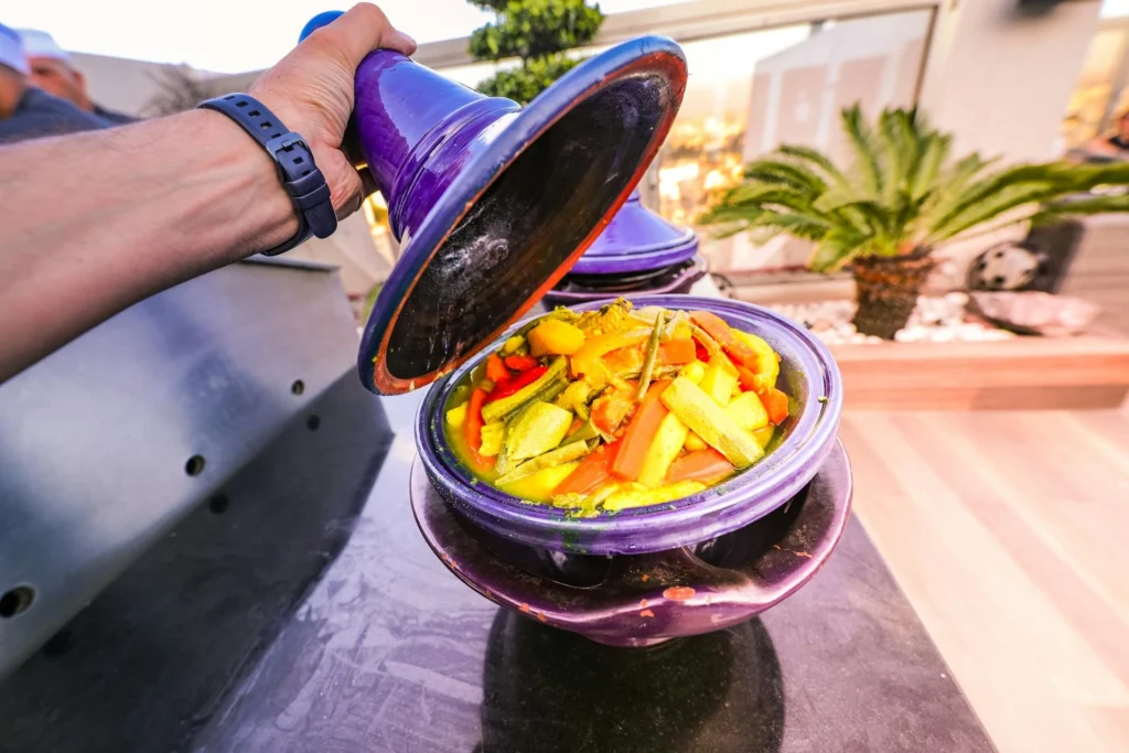 Traditional Moroccan tajine served in a clay pot with vegetables and meat.